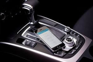 Smartphone mit geöffneter Fahrtenbuch App liegt im Auto.