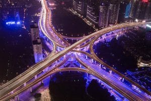 Beleuchtetes Autobahnkreuz in der Nacht zeigt die Vernetzung von Connected Cars