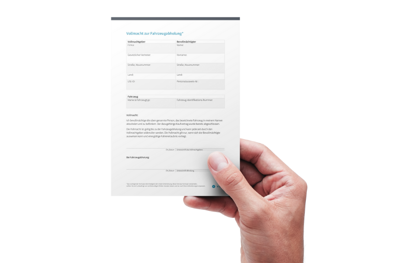 Vollmacht zur Fahrzeugabholung in einer Hand gehalten