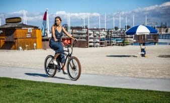 Frau fährt ein E-Bike am Strand