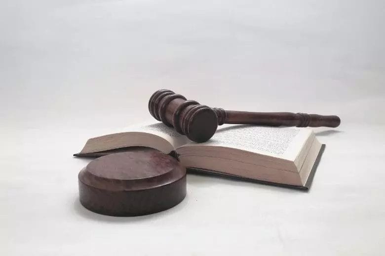 DGUV Vorschrift - Richterhammer liegt auf Gesetzbuch